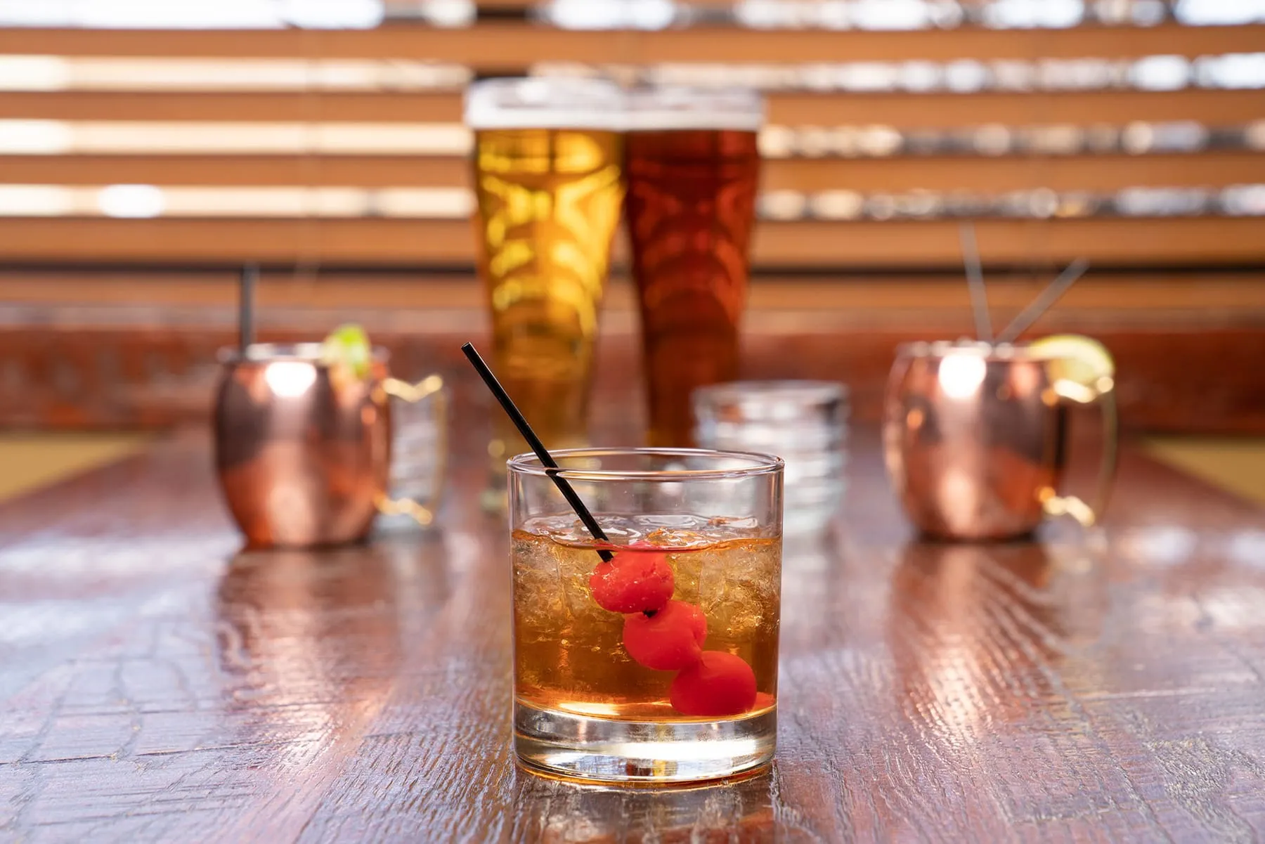 Cocktails on the bar top, copper mule mugs behind